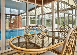 a patio with a table and chairs next to a pool at Milton House Group Retreats in Bedford