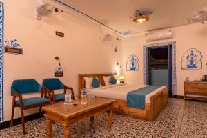 a bedroom with a bed and a table and chairs at Storica Stays in Jodhpur