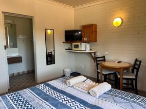 ein Zimmer mit einem Bett und einem Tisch und einer Mikrowelle in der Unterkunft Cann Valley Motel in Cann River