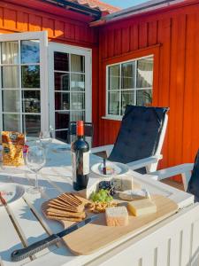 a table with a bottle of wine and a plate of food at Magical Barn Near The Sea in Ytterby