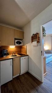 a small kitchen with a sink and a room with a bed at L'ETERLOU, Studio Centre station in Risoul