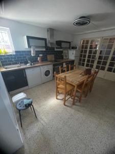 a kitchen with a wooden table and chairs in it at New Appartement RDC de Villa 60 m2 proche plage in La Ciotat +12 photos