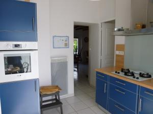a kitchen with blue cabinets and a stove top oven at maison 6 personnes in Locquirec