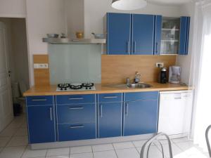 a kitchen with blue cabinets and a sink at maison 6 personnes in Locquirec +3 photos