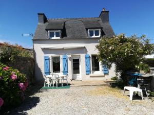 a white house with blue doors and tables and chairs at maison 6 personnes in Locquirec