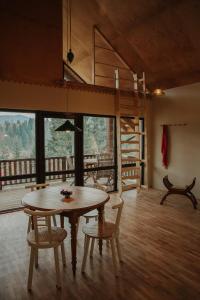 une salle à manger avec une table et des chaises et un balcon dans l'établissement Ліснів, à Tatariv