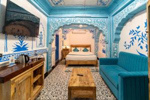 a blue room with a bed and a couch at Storica Stays in Jodhpur