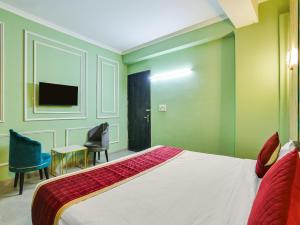 Un dormitorio con una cama, un escritorio y un televisor. en The Swarnim Vista Hotel, en Noida