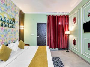 Un dormitorio con una cama y una cortina roja. en The Swarnim Vista Hotel, en Noida