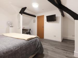 a bedroom with a bed and a flat screen tv at Room 1 At The Cwtch in Chepstow +3 photos