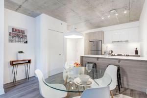 une cuisine avec une table en verre et des chaises blanches dans l'établissement Corporate Stays Le Shaughn 1 Bedroom, à Montréal 6 autres photos