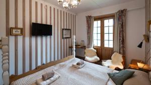 Un dormitorio con una cama y un televisor en la pared. en Tallhöjden hotel & Nature Lodge, en Simlångsdalen