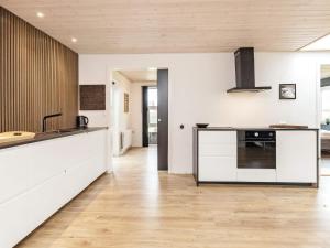 een keuken met witte kasten en een aanrechtblad bij 8 person holiday home in Ålbæk-By Traum in Ålbæk +43 foto's