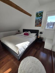 a bedroom with a large bed with white sheets at Appartement proche Strasbourg in Bischheim