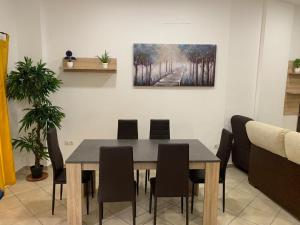 a dining room table with chairs and a painting on the wall at Apartamento centro ciudad in Algeciras +7 photos