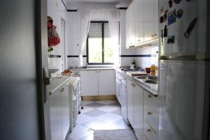 a white kitchen with white cabinets and a window at TRIANA HOME & Free Parking in Seville