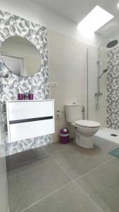 un bagno con un water, un lavandino e uno specchio di CASA MANUEL - SANTA MARTA COMPLEX a Costa Del Silencio