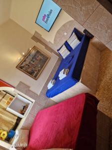 vistas a un dormitorio con cama azul en 4 Seasons Suites Paradise Athens Airport 2, en Markopoulo