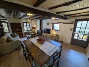 a living room with a wooden table and a couch at Casa Rústica y Chic con Chimenea y Vistas Panorámicas de La Vall de Boí in Cardet