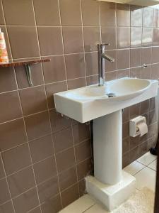 a white sink in a bathroom with brown tiles at Halibut Suite in Strand