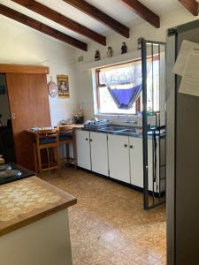 a kitchen with white cabinets and a sink and a window at Halibut Suite in Strand +13 photos