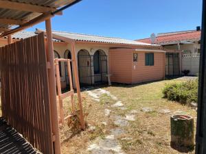an outside view of a house with a fence at Halibut Suite in Strand