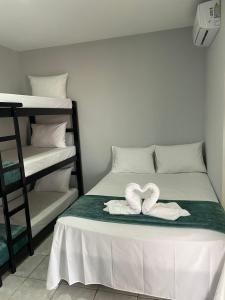 a bed with two towels in the shape of a heart at Pousada Siri do Mar in Pontal do Paraná
