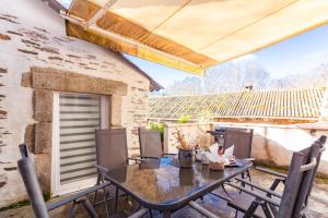 a patio with a table and chairs and a building at Dame nature in La Tourette-Cabardès