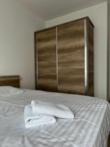 two white towels sitting on top of a bed at Sunflower Apartments in Prishtinë +164 photos
