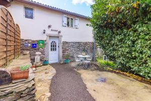 a house with a stone wall and a white door at Dame nature in La Tourette-Cabardès