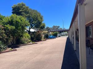 eine leere Straße neben einem Gebäude mit einem blauen Auto in der Unterkunft Cann Valley Motel in Cann River