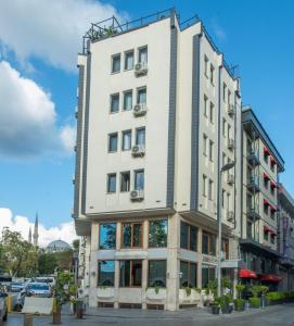 Un edificio alto y blanco en una calle de la ciudad. en Hotel Öncü, en Estambul