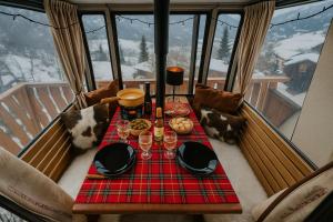 a table with food and wine glasses on a balcony at Chalet 6 personnes avec sauna in Leysin