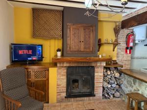 a living room with a fireplace and a tv at Casas Rurales Arcoiris in Riópar