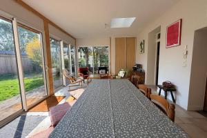 ein Esszimmer mit einem großen Tisch mit Stühlen und einem großen Fenster in der Unterkunft Confortable maison familiale à 5 minutes du lac in Saint-Simon