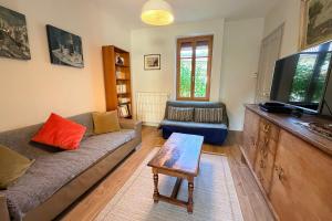 ein Wohnzimmer mit Couch und Flachbildfernseher in der Unterkunft Confortable maison familiale à 5 minutes du lac in Saint-Simon + 25 Fotos