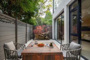 un patio con una mesa de madera y 2 sillas en Guilin Lakeview Boutique Lodge, en Guilin