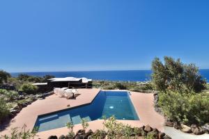 a swimming pool with a view of the ocean at Dammusi Sciuvechi in Pantelleria
