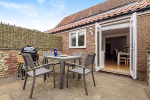 eine Terrasse mit Tisch und Stühlen vor einem Gebäude in der Unterkunft 1 Crarves in Docking
