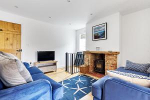 ein Wohnzimmer mit 2 blauen Sofas und einem Kamin in der Unterkunft 1 Crarves in Docking
