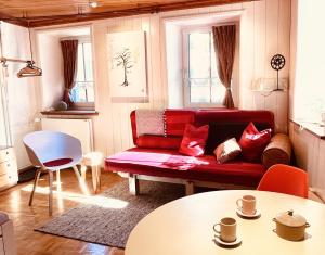 a living room with a red couch and a table at Chasina Rosa in Scuol