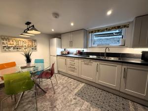 een keuken met een tafel, een wastafel en een aanrecht bij Castle Cottage - Central seaside town in Ryde