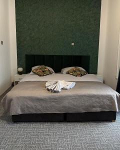 een slaapkamer met een groot bed met een groen hoofdeinde bij Dvoupokojový apartmán Penzion Hrádek in Nový Hrádek