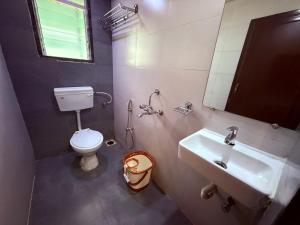 a bathroom with a sink and a toilet and a mirror at Hotel Arya Residency Rabale in Airoli +37 photos
