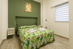 a bedroom with a bed with a green wall at Fichi d'India Appartamenti in San Pietro in Bevagna