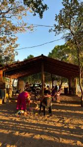 a group of people sitting under a wooden pavilion at Chácara Maranata in Manaus