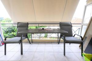 une table et des chaises assises sur un balcon dans l'établissement Lussuoso Casa 2, à Patras