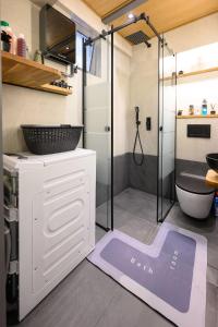 La salle de bains est pourvue d'une douche et d'un tapis violet. dans l'établissement Lussuoso Casa 2, à Patras 10 autres photos