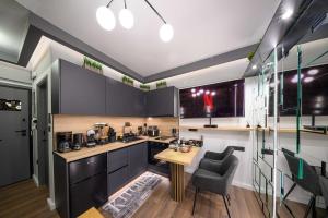 a kitchen with black cabinets and a table and a chair at Lussuoso Casa 2 in Patra