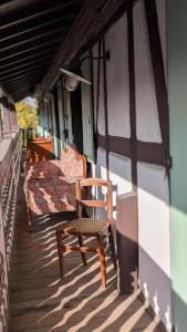 a wooden chair sitting on the porch of a house at Les Perles du Ried - Gîte 202 in Boofzheim